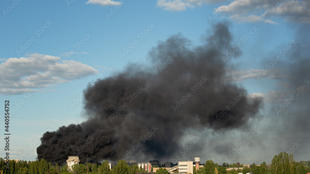 Fototapeta premium Burning building with black smoke. Huge smoke clouds after explosion