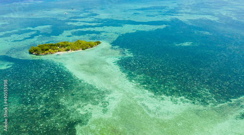 Tropical island and blue sea with a coral reef against the sky and clouds. Summer and travel vacation concept. Panglao, Philippines. photo