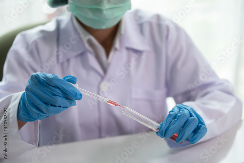 Scientist drop a sample chemical liquid to test tube in medical laboratory, Science and chemistry, Researcher test a sample concept