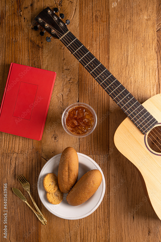 Gutar and iced coffee and book and bread on the wooden table Gutar and iced coffee and book and bread on the wooden table