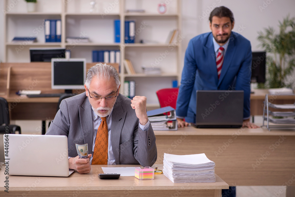 Fototapeta premium Old male boss and young male employee in remuneration concept