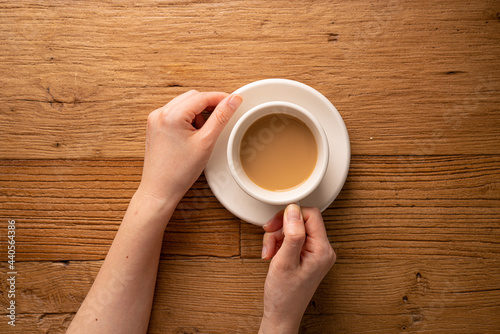 Hands with coffee on the wooden table