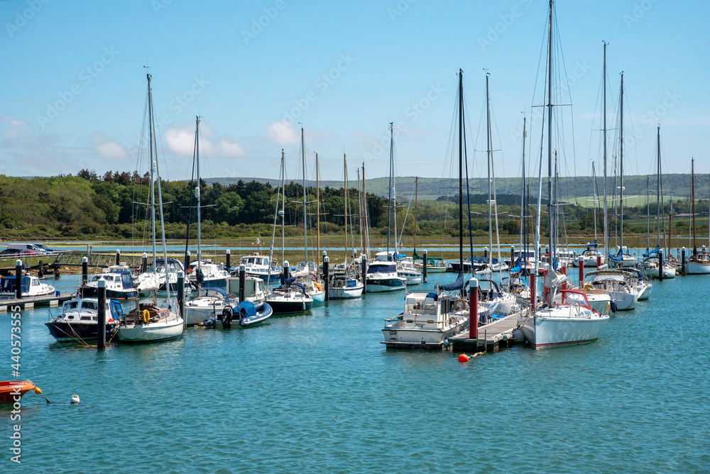 Englaand, UK. 2021.  Leisure boats and yachts berthed on a floating pontoon mid river.