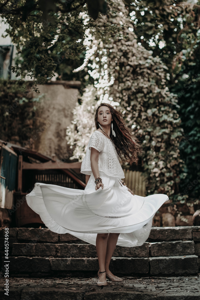 Young hippie woman in white boho long skirt walking in the street of Istanbul city in summer