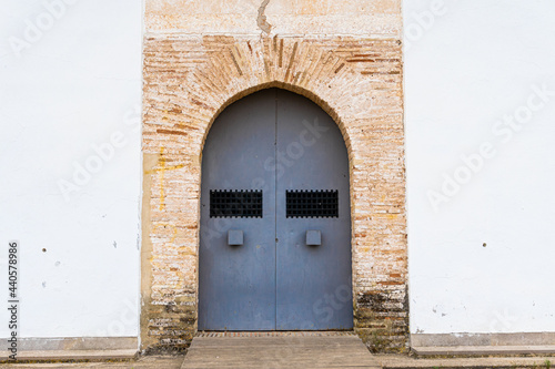 Metal door in a church, with a rustic brick porch.  © MiguelAngel