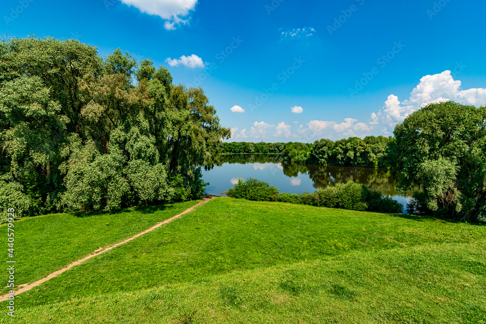 Beautiful natural scenery of river. Panoramic view of valley of river. Peaceful summer landscape with green hills, beautiful woods, meadows, river curves and fields