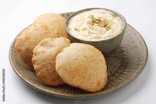 Shrikhand & Puri, Shrikhand is an Indian sweet dish made of strained curd, garnished with dry fruits and saffron. Served with Puri, Deep fried flat bread. 