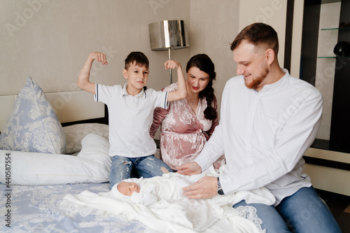 Happy family with a toddler in the bedroom. the first day of the newborn at home