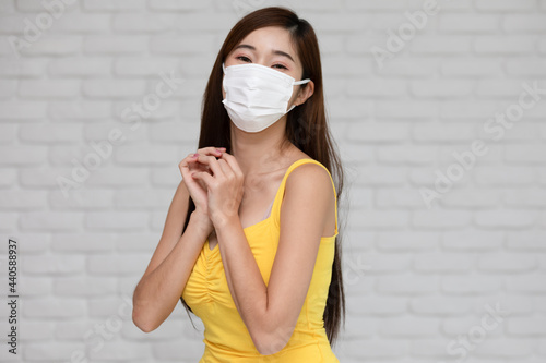 Obraz na plátně Wellness asian young woman wear face mask and yellow camisole holding hands prou