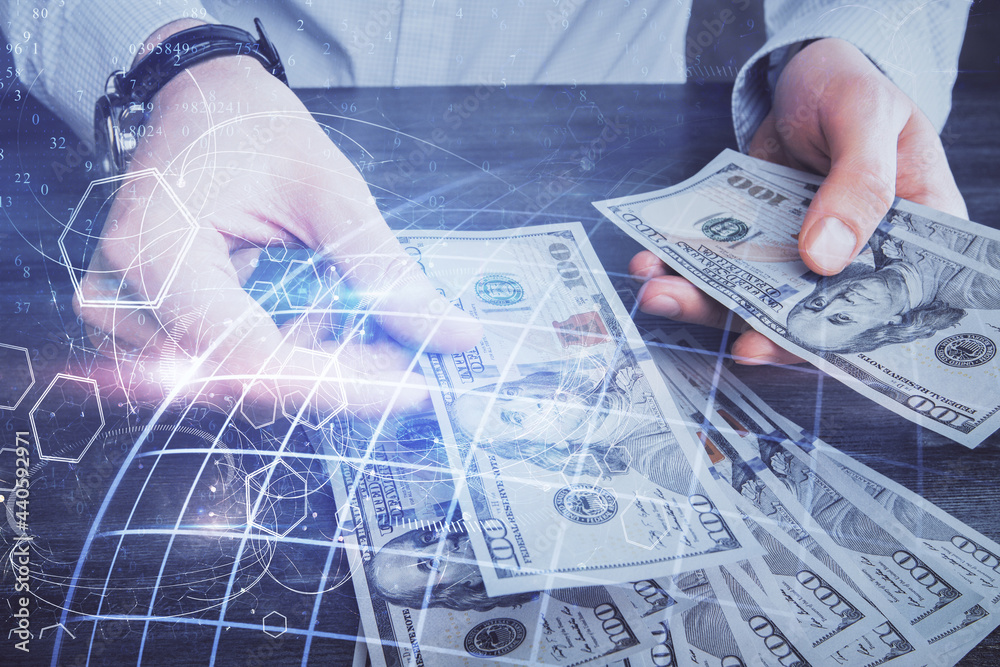 Double exposure of world map drawing hologram and us dollars bills and man hands. Double exposure of world map drawing hologram and us dollars bills and man hands.