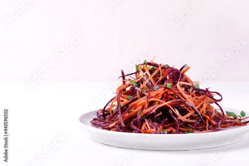 Salad with orange and purple carrots grated into a heap on the plate. Vegan meal photo