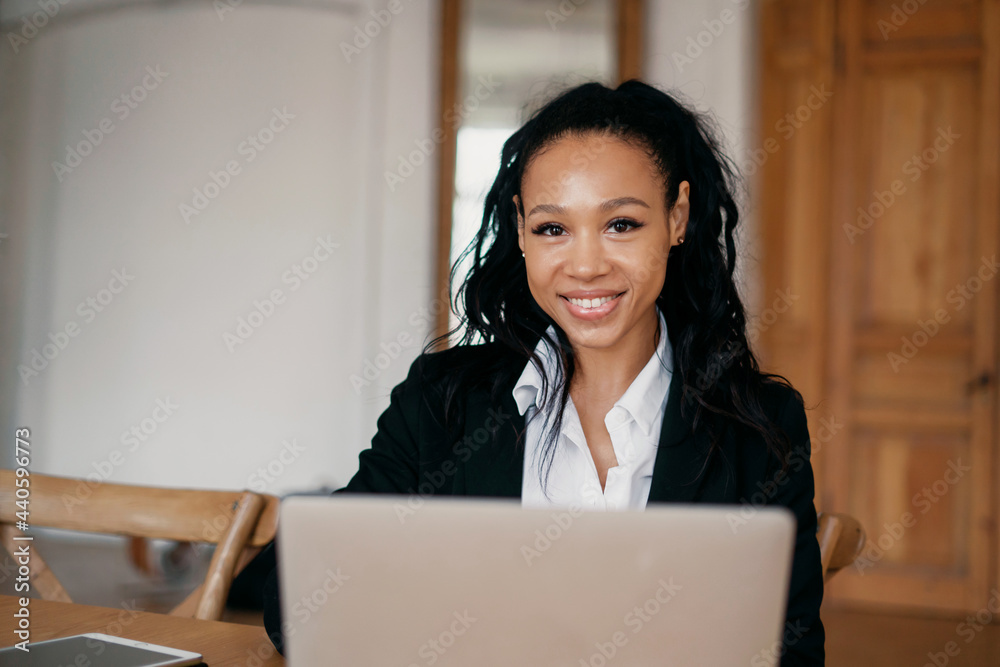 The financier works on a computer. Businesswoman afro smiles manager working on laptop. The lawyer sits in a modern rented office. The financier works on a computer. Businesswoman afro smiles manager working on laptop. The lawyer sits in a modern rented office.