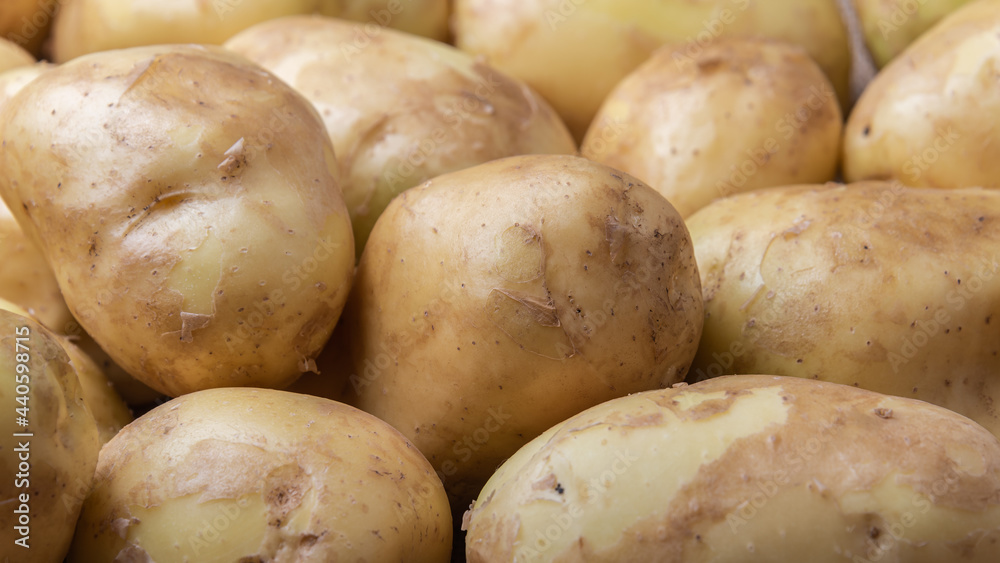 Food background with fresh raw potatoes on a burlap. New harvest. Food background with fresh raw potatoes on a burlap. New harvest.