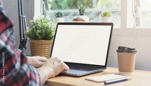 Businessman hands using laptop with blank screen. Mock-up of computer monitor. Copyspace ready for design or text.