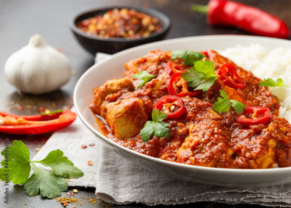 Spicy Chicken Pathia curry with basmati rice in a white plate. healthy food. Spicy Chicken Pathia curry with basmati rice in a white plate. healthy food.
