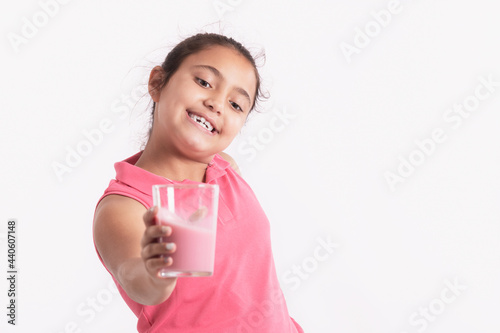 Happy little girl holding a strawberry juice glass