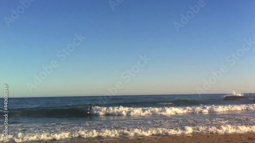 Surfers in the Mediterranean: A surfer rides a wave at full speed while the rest wait their turn.