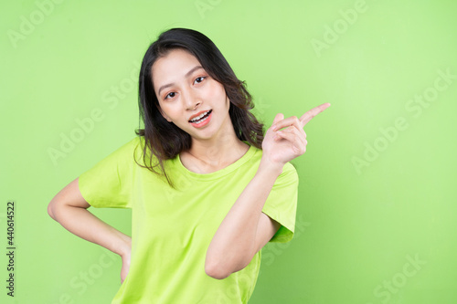 Young Asian woman posing on pink background