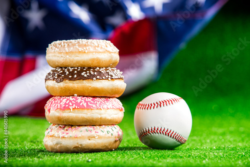 Canvas Print Donuts and baseball over green grass and american flag background