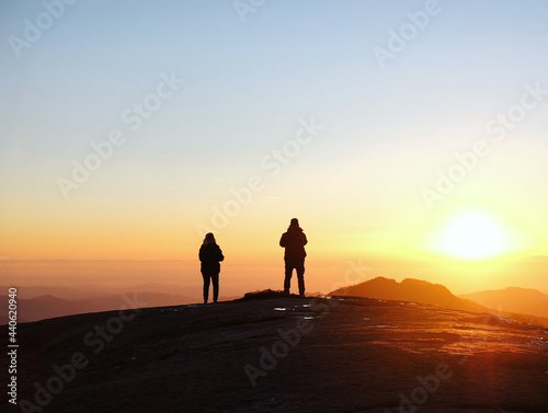 Two hikers meet the winter sunset on the Moro rock in Sequoia & Kings Canyon National Park, California, USA
