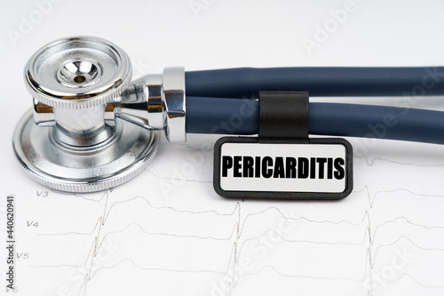 On the cardiogram is a stethoscope and a plate with the inscription - pericarditis photo