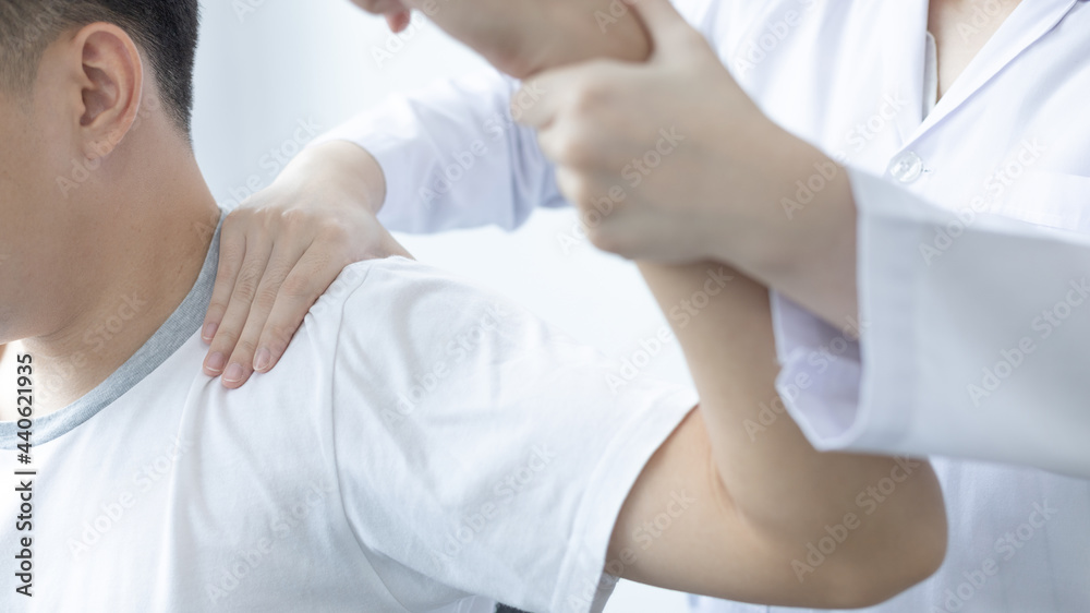 Physical therapy, Female physiotherapist treats arms and shoulders pain for a male patient attending in clinic, Bone arrangement, Non-surgical medical treatment, Modern medical techniques.