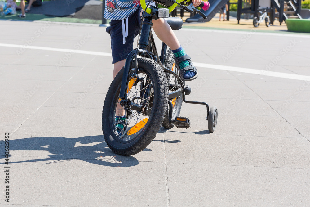 Obraz premium A child learning to ride a bicycle. Summer time, holidays. childhood.