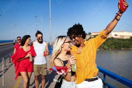Group of happy friends drinking outdoors before festival