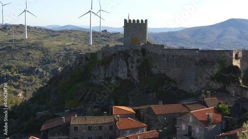 View of Sortelha castle and antique stone houses and wind turbines, in Portugal photo