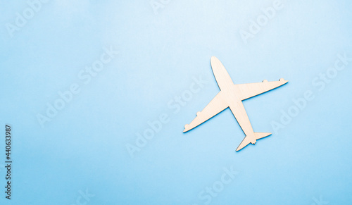 Model of a toy airplane of white color on a blue background with place for adding text, concept of air transportation, tourism, travel.