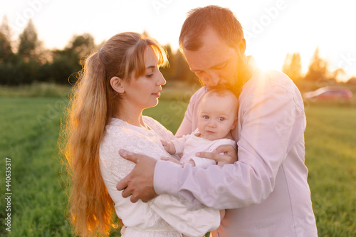 Traditional family in light clothes in the field nature. Walk at sunset. Christians. The priest with his wife and child are happy together. Positive parenting. Digital detox freedom. Vegan. Sunlight