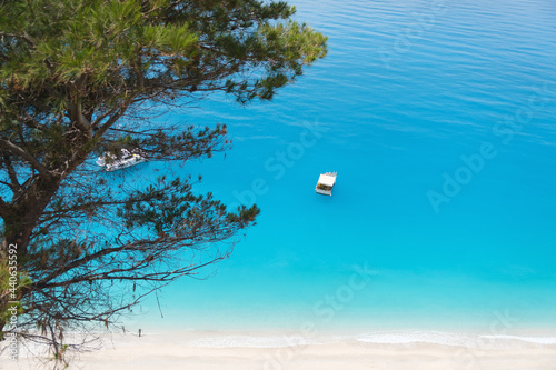 Top view of small fishing boat in aqua blue sea water. photo