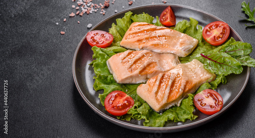 Delicious fresh salad with fish, tomatoes and lettuce leaves