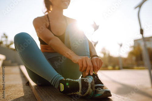 Fit Young woman in sportswear doing yoga  fitness exercise on the street. Warming up your muscles before an intense workout in the morning. Sport  Active life  sports training  healthy lifestyle.