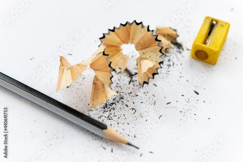 A sharpened pencil with shavings isolated with a white background.