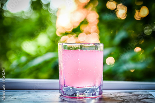 glass cup with pink cocktail on wooden table