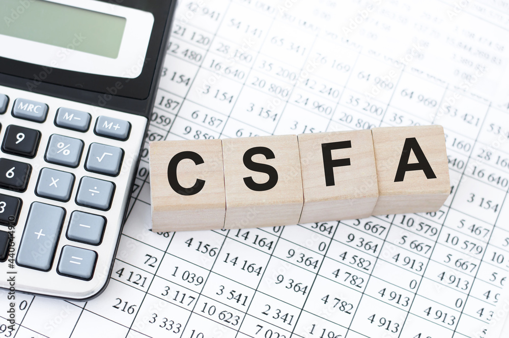 concept acronym CSFA on wooden cubes on the background of numbers near the calculator. Business concept concept acronym CSFA on wooden cubes on the background of numbers near the calculator. Business concept