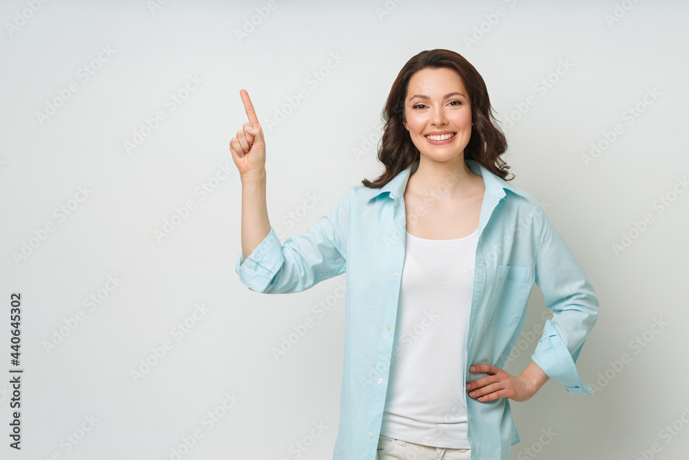 Young woman smiling and gesturing to copy space. Young woman smiling and gesturing to copy space.