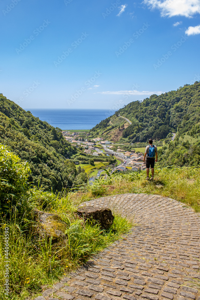 Hiker enjoying view to Atlantic ocean, Azores travel destination, nature.