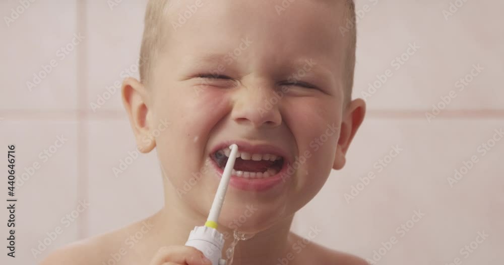 Close-up of Little Boy Holding Water Flosser and Cleaning His Teeth while Looking at Camera in a Bathroom
Close-up of Little Boy Holding Water Flosser and Cleaning His Teeth while Looking at Camera in a Bathroom