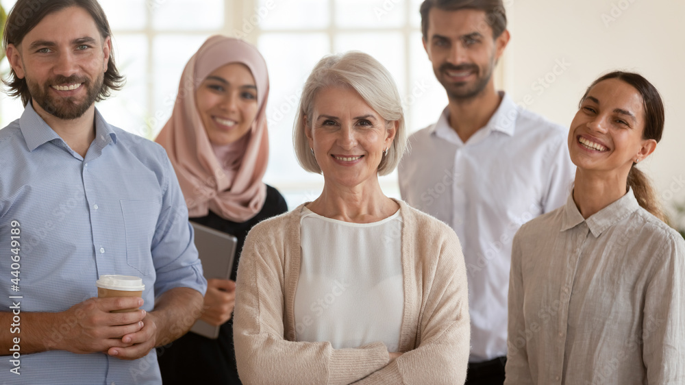 Head shot portrait smiling multiethnic employees group with mature businesswoman executive team leader looking at camera, happy diverse colleagues posing for photo in office, unity and cooperation Head shot portrait smiling multiethnic employees group with mature businesswoman executive team leader looking at camera, happy diverse colleagues posing for photo in office, unity and cooperation