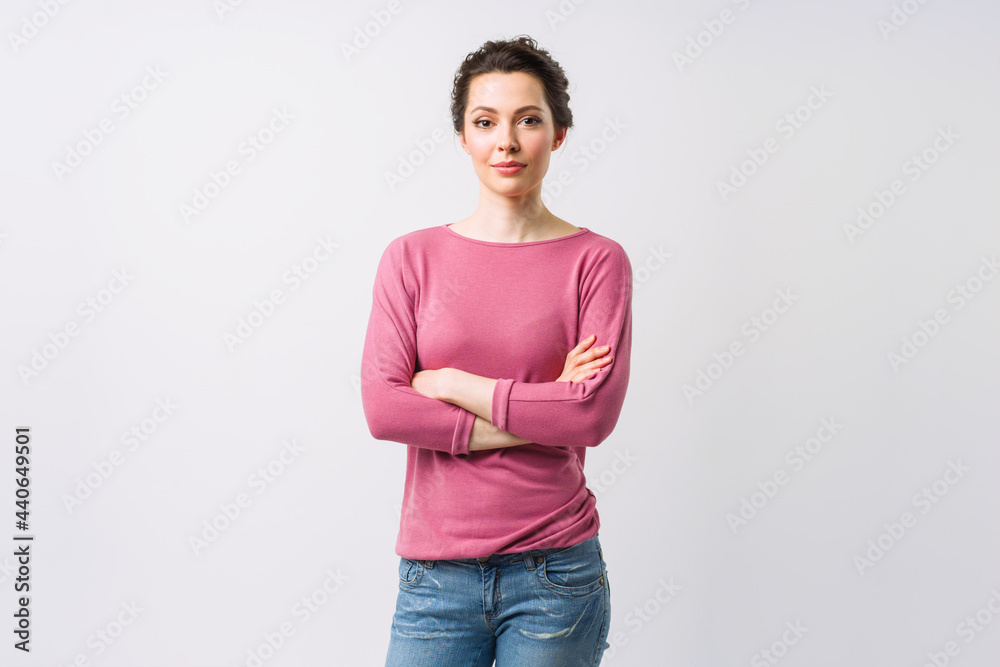 Young woman portrait. Adorable brunette in a sweater looking at the camera with her arms crossed. Young woman portrait. Adorable brunette in a sweater looking at the camera with her arms crossed.