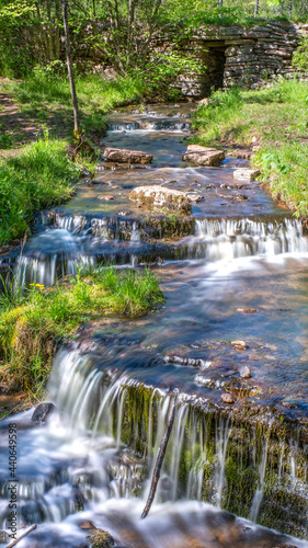 Martorpsfallet Waterfall, Delicate creek decending in lush forest on wet limestone rock on Kinnekulle nature reserve, Sweden. photo