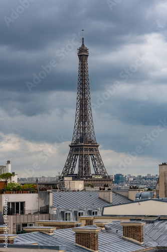 Paris, the Eiffel Tower, beautiful monument, and typical roofs, stormy weather 