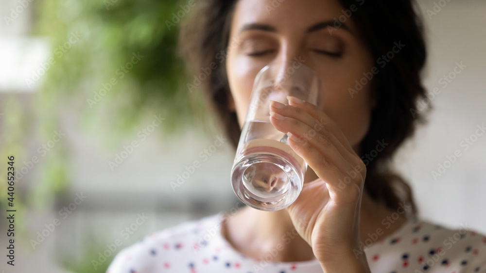 Close up cropped of beautiful woman drinking fresh pure mineral water with closed eyes, satisfied young female holding glass, healthy lifestyle and good daily habit concept, natural beauty, skincare Close up cropped of beautiful woman drinking fresh pure mineral water with closed eyes, satisfied young female holding glass, healthy lifestyle and good daily habit concept, natural beauty, skincare