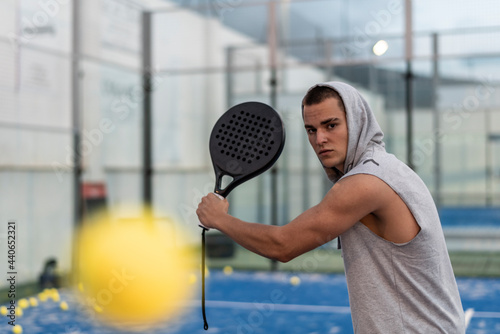 Young man with urban style trains paddle tennis on outdoor court