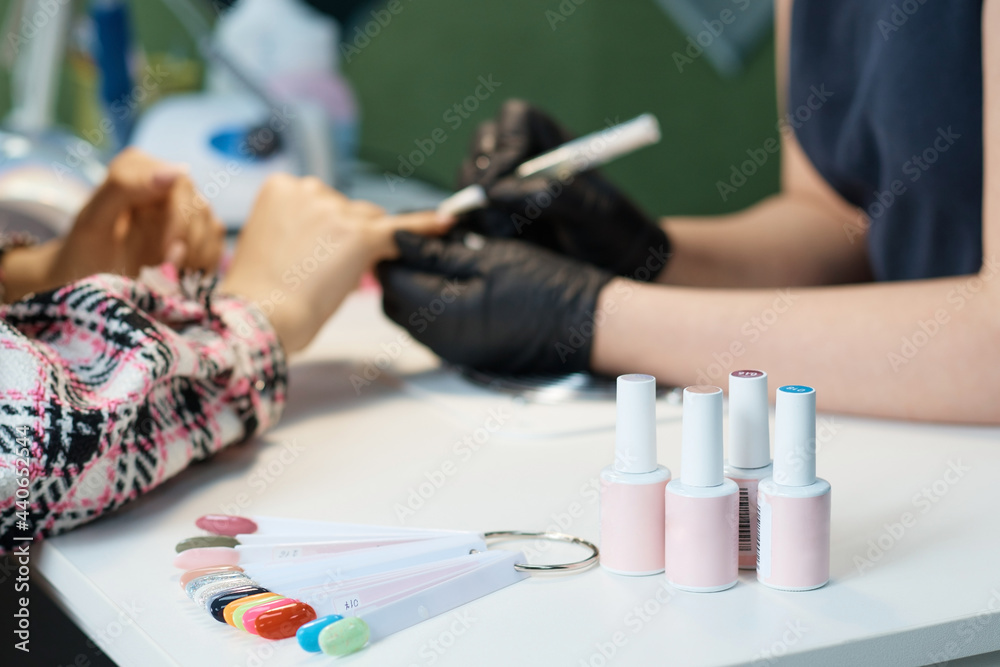different tubes of nail polish and a palette of nail colors, a beauty salon, a manicure table, a blurred background different tubes of nail polish and a palette of nail colors, a beauty salon, a manicure table, a blurred background