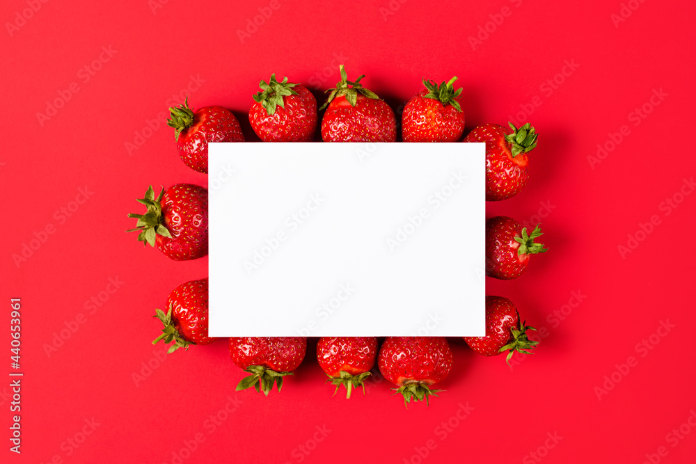 Creative layout made of strawberries on red background with paper card note. Flat lay. Fruit concept. Food layout Creative layout made of strawberries on red background with paper card note. Flat lay. Fruit concept. Food layout