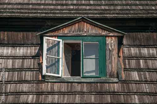 otwarte okno na poddaszu drewnianego domu