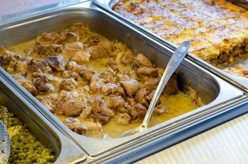 Closeup shot of lamb fricassee inside a bain-marie pot in a cafeteria photo